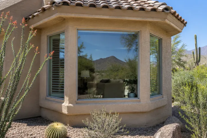 Three-panel bay window from outside a stucco home
